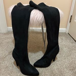 Suede thigh high heeled boots.
